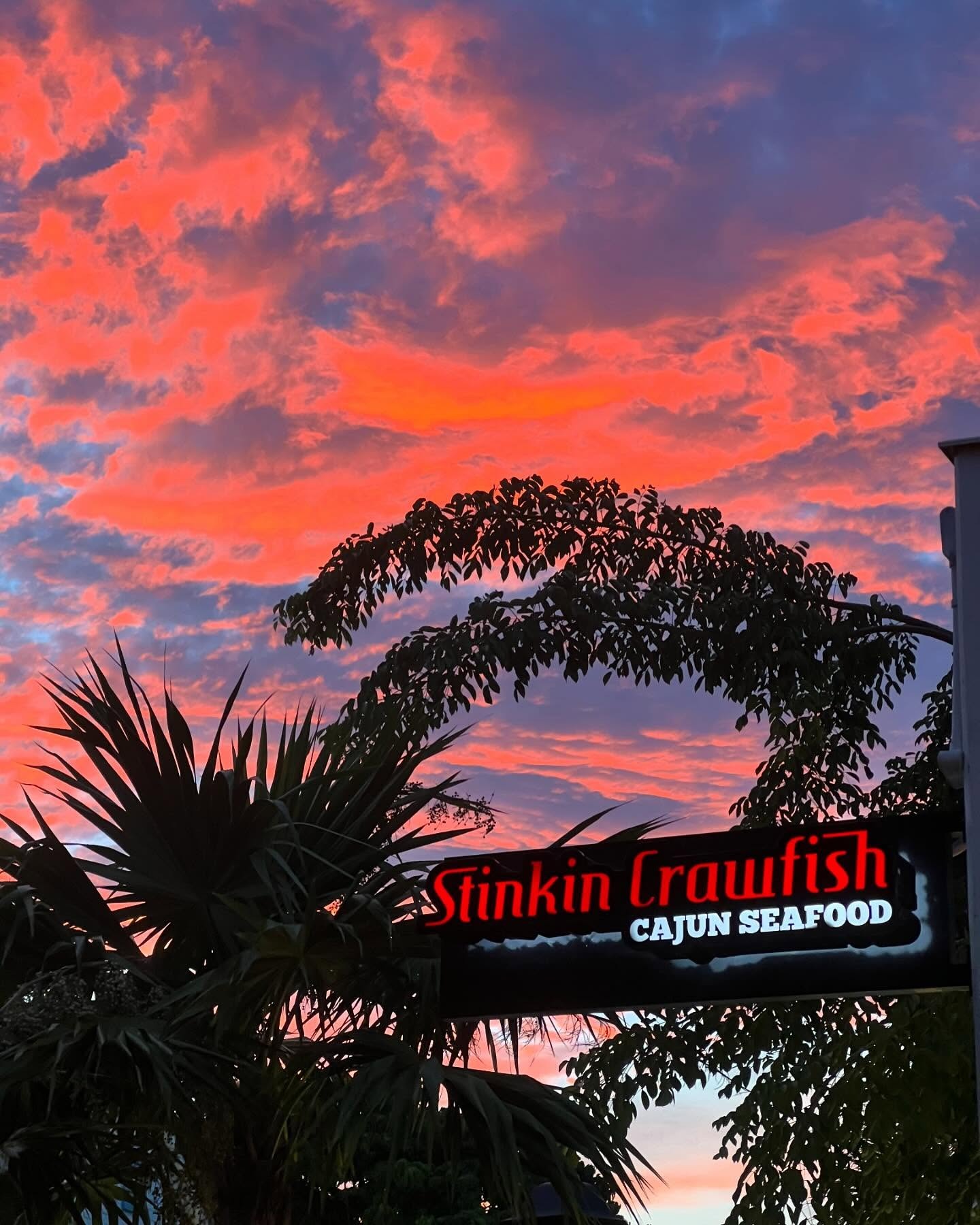 Stinkin Crawfish neon sign at sunset